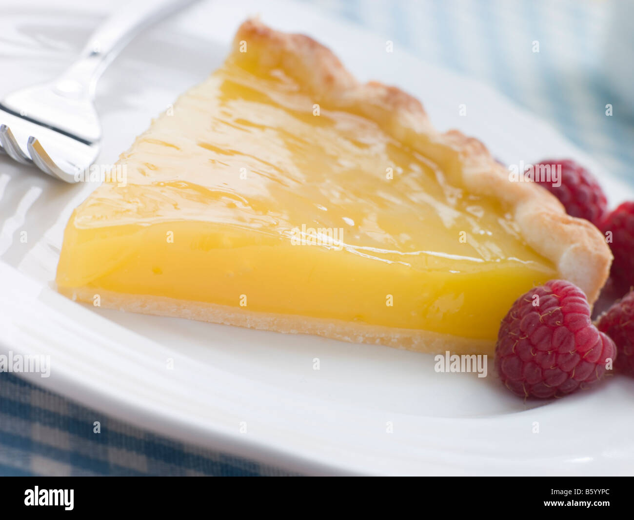 Slice of Lemon Curd Tart with English Raspberries Stock Photo