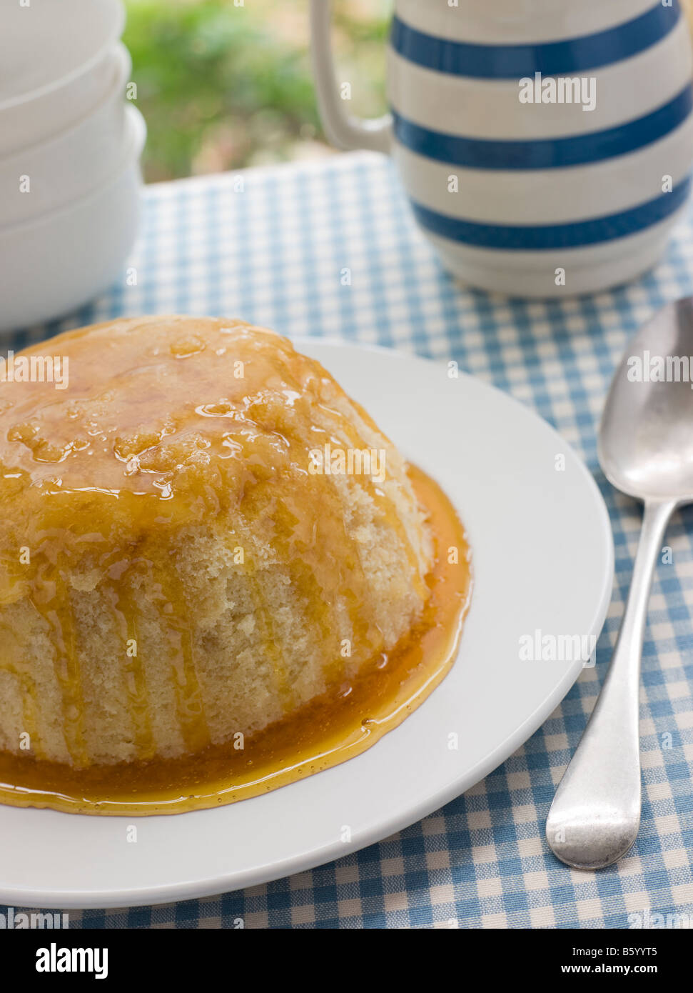 Steamed Syrup Sponge with a jug of Custard Stock Photo