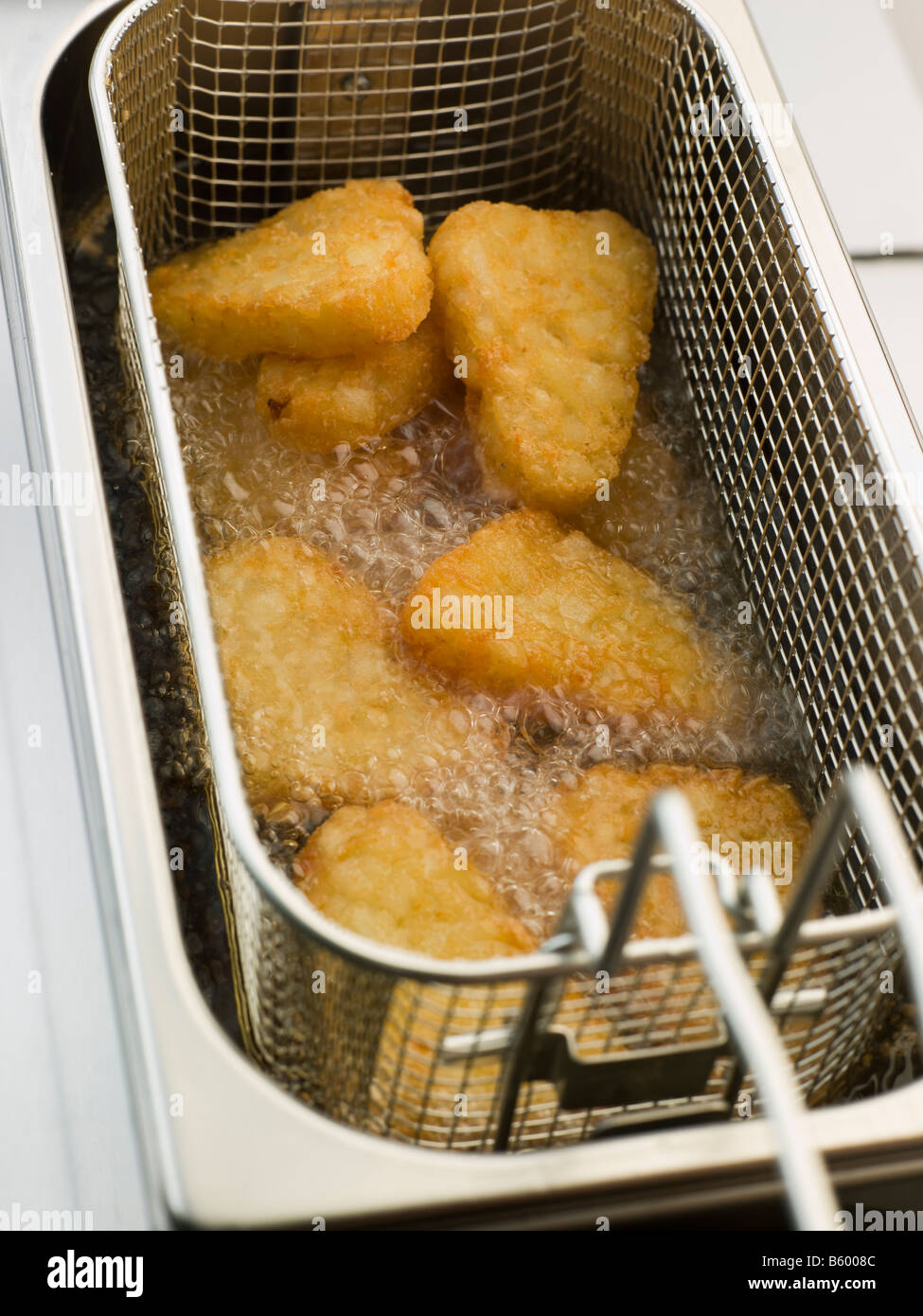 Hash Browns being Deep Fried in Corn Oil Stock Photo