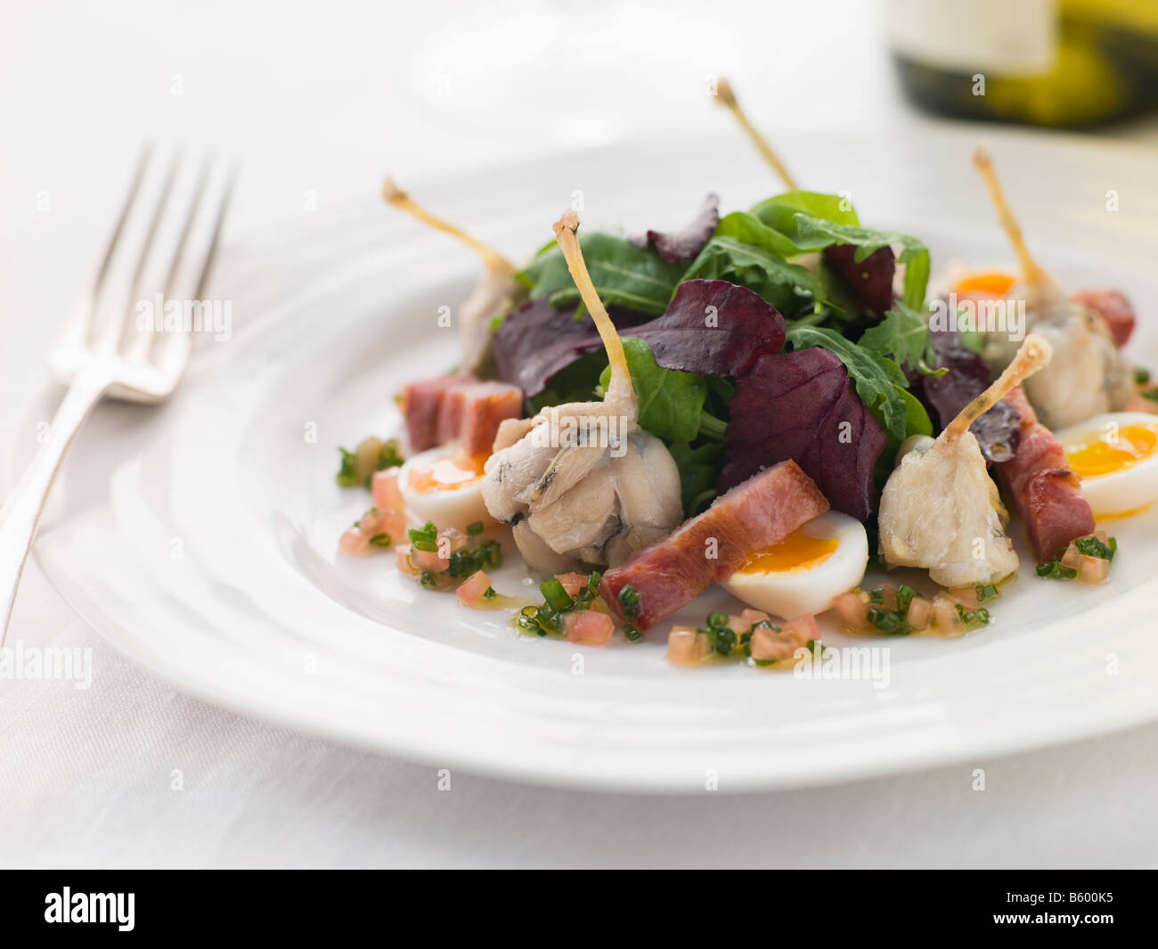 Salad of Frog Legs Lardons and Quail Eggs Stock Photo