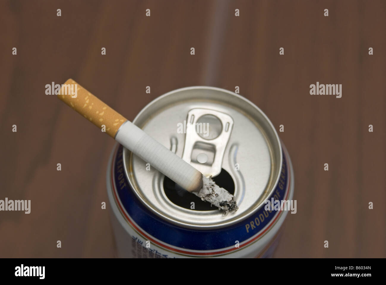 cigarette on a can of beer used as ashtray Stock Photo Alamy