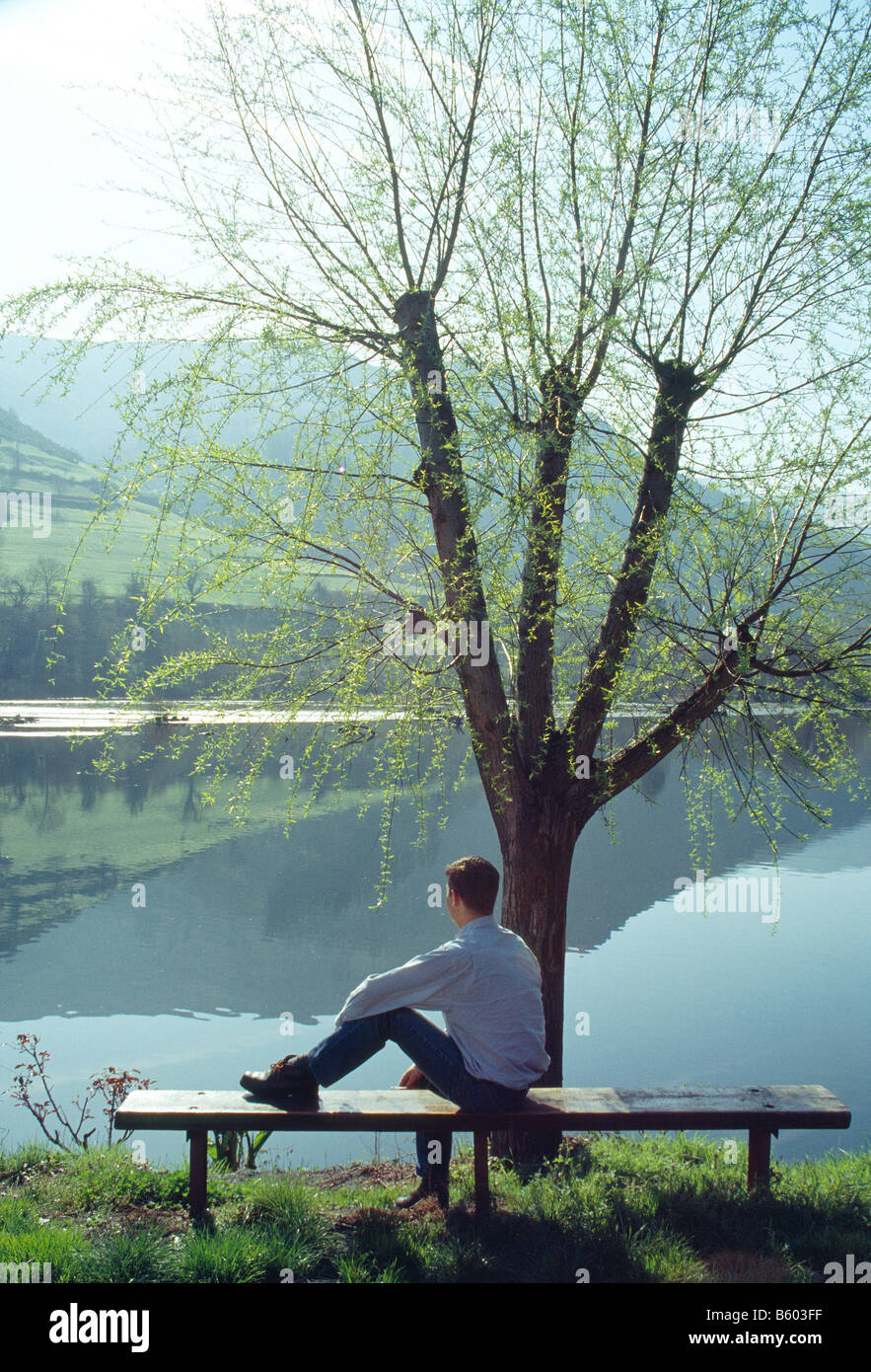 Man sitting and looking at the lake. Florida reservoir. Tineo. Asturias province. Spain. Stock Photo