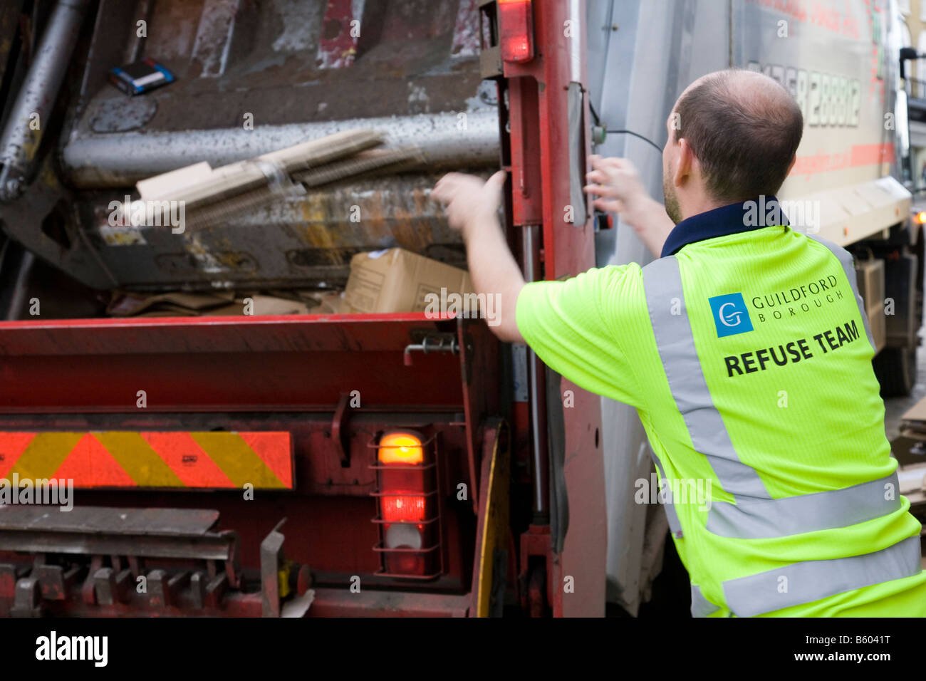 A refuse collector loads cardboard into a recycling truck, Guildofrd