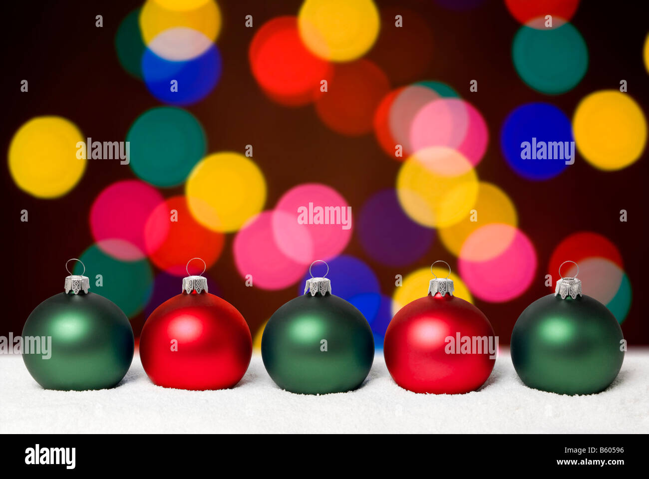Christmas balls lying on the snow. Background - colorful christams lights. aRGB. Stock Photo
