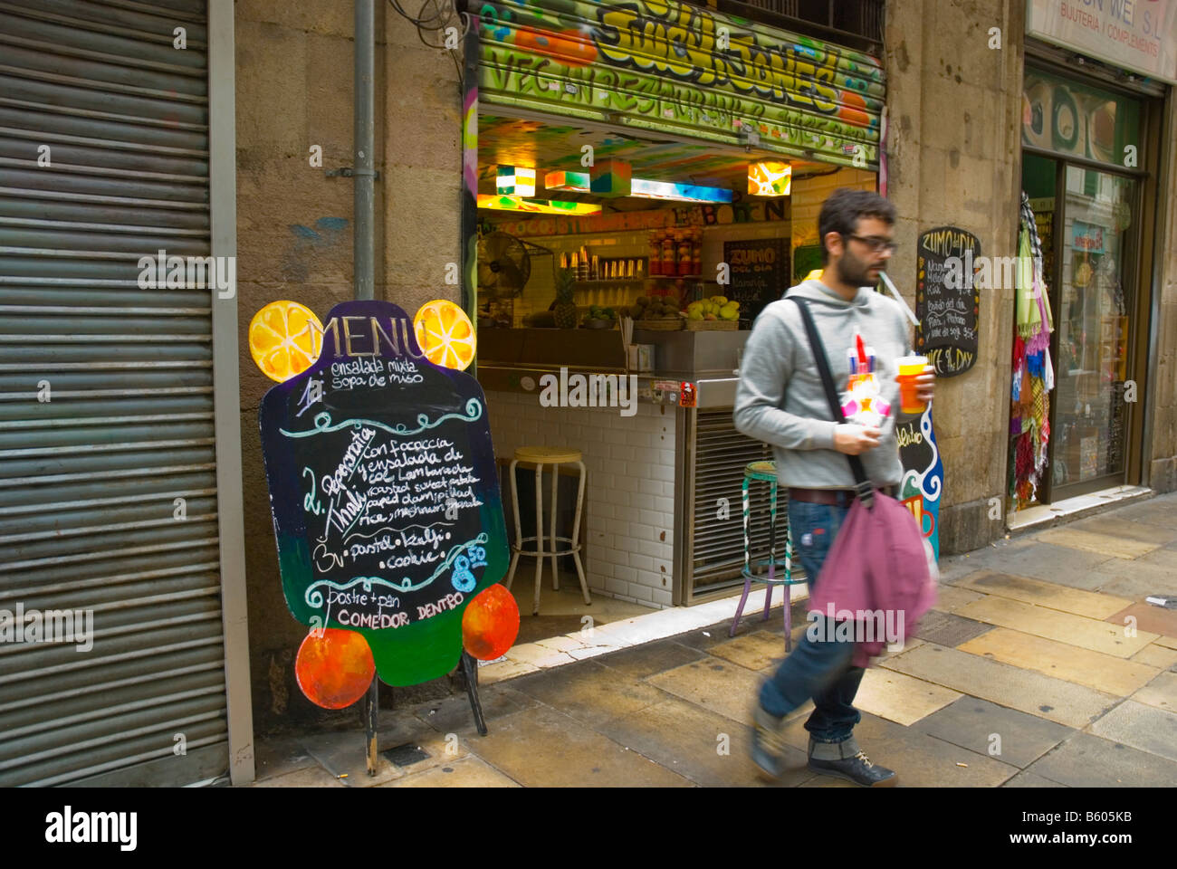 Man coming out of Juicy Jones vegeterian restaurant and juice bar in Barri Gotic quarter of Barcelona Europe Spain Stock Photo