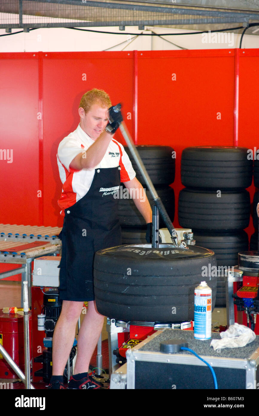 F1 Tyre Mechanic fitting a Tyre at Silverstone Race Track Stock Photo