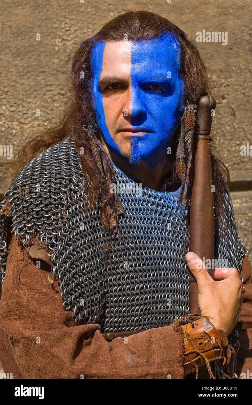 Street performer at Edinburgh Fringe festival dressed as Scottish medieval soldier clansman with face painted with wode, Edinburgh, Scotland Stock Photo