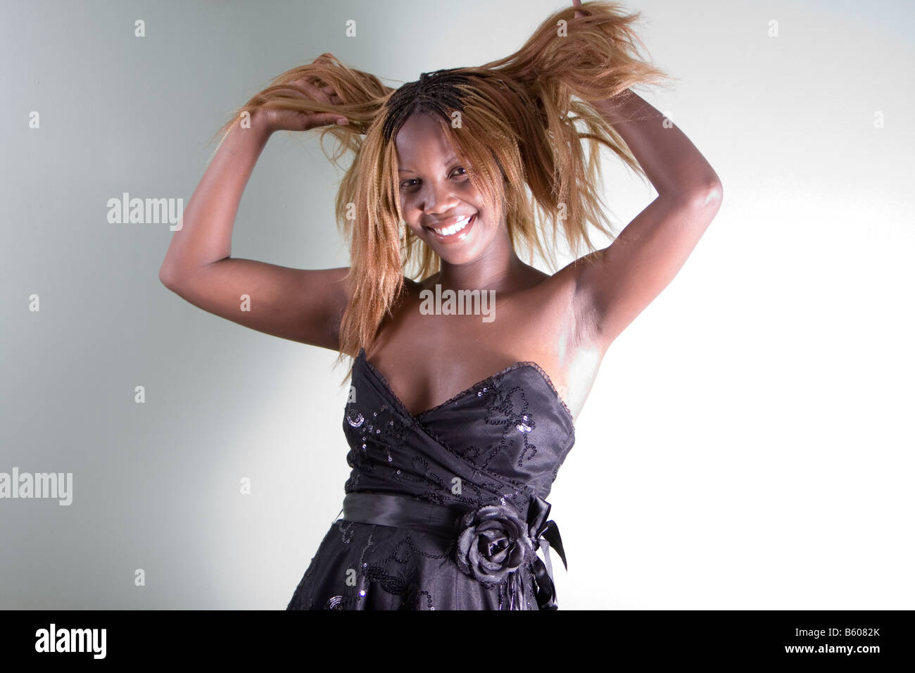 smiling african english girl holding her hair wearing a ball gown Stock Photo
