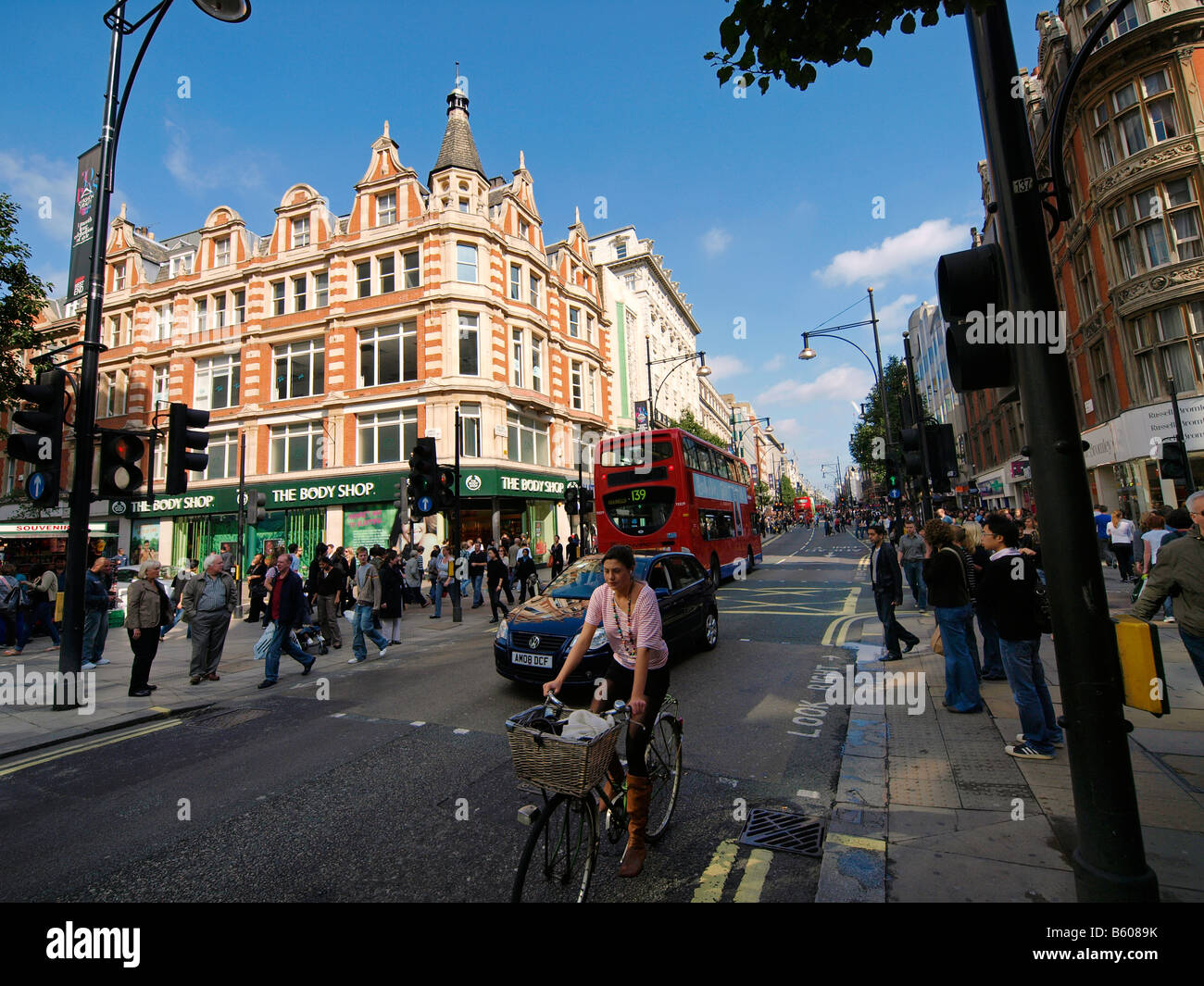 Oxford Street London UK with Body Shop store visible and woman riding a bicycle Stock Photo