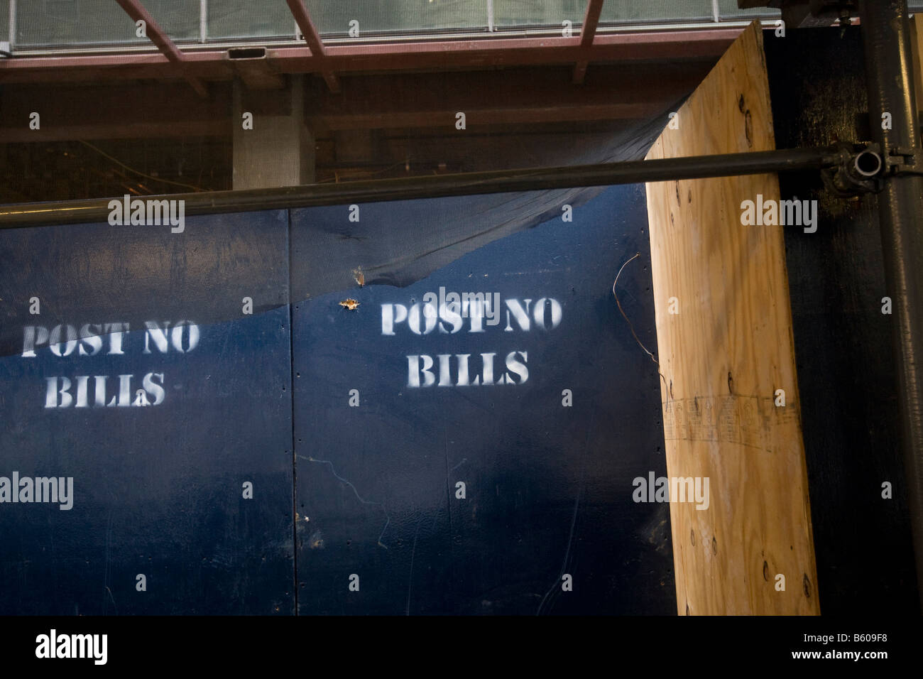 Post no bills is painted in white letters on a blue wooden wall around a construction area in New York 23 November 2008 Stock Photo