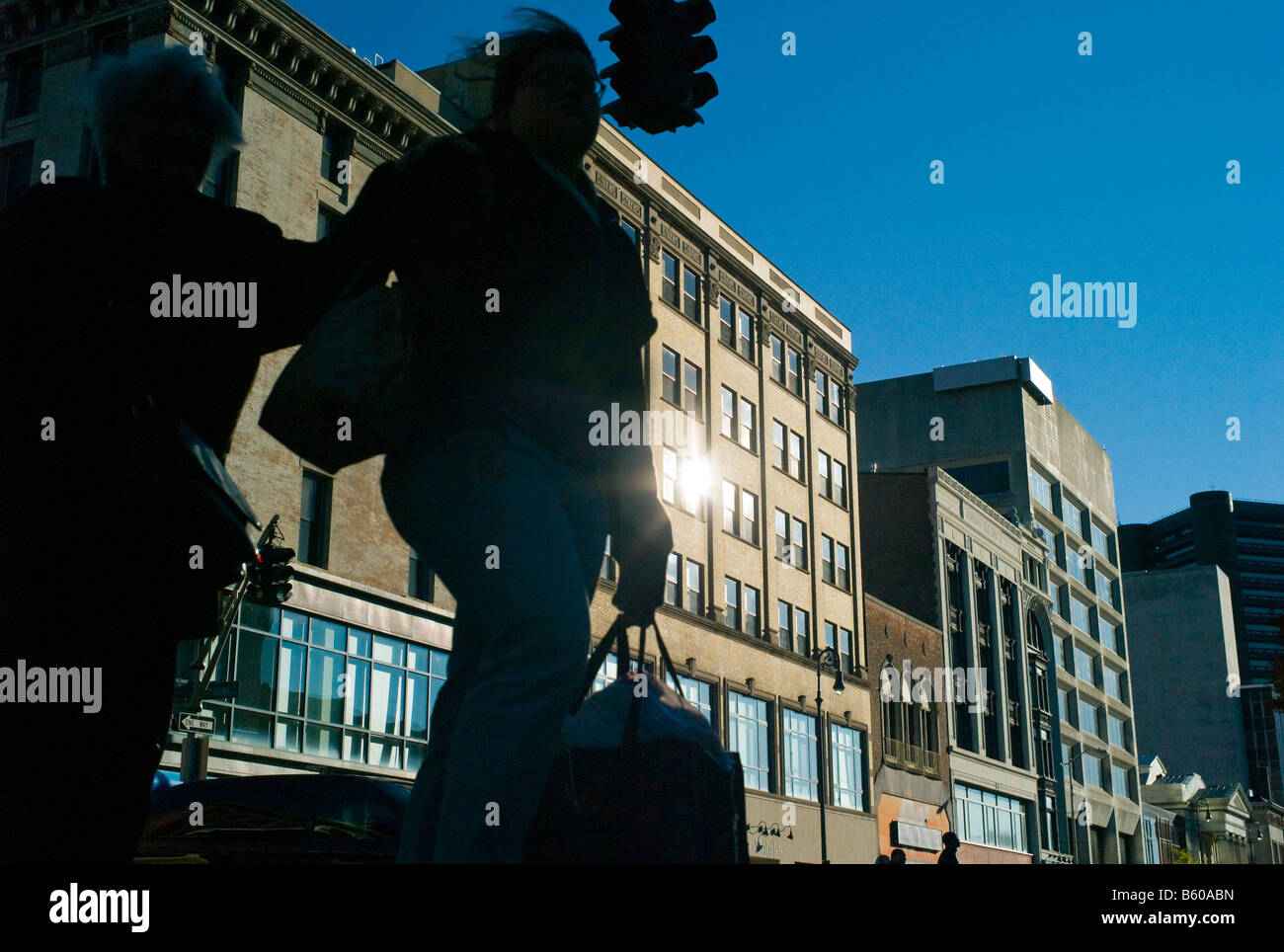 Two women shoppers with bags walk through a city with office buildings in rear in New Haven CT a modern city Stock Photo