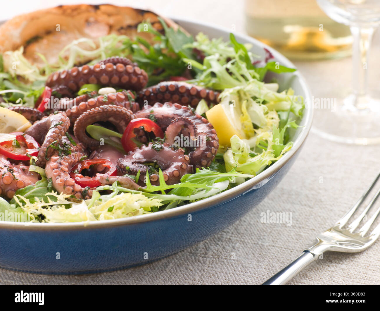 Baby Octopus Salad with Frisse Roquette and Chargrilled Bread Stock Photo