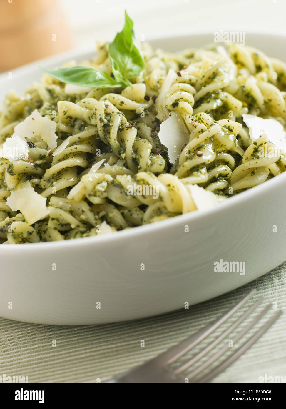 Bowl of Fusilli Pasta dressed in Pesto with Parmesan Shaves Stock Photo