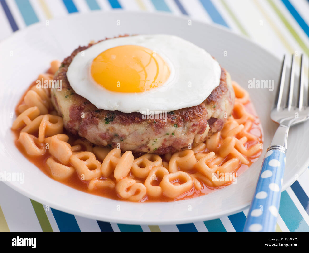 Corned Beef Hash Cake with Alphabet Pasta and a Fried Egg Stock Photo