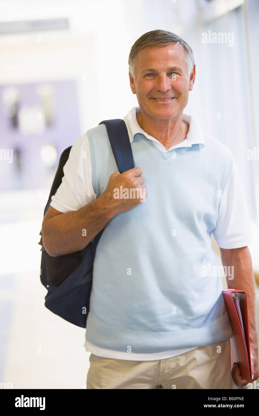 Man standing in corridor with backpack (high key) Stock Photo