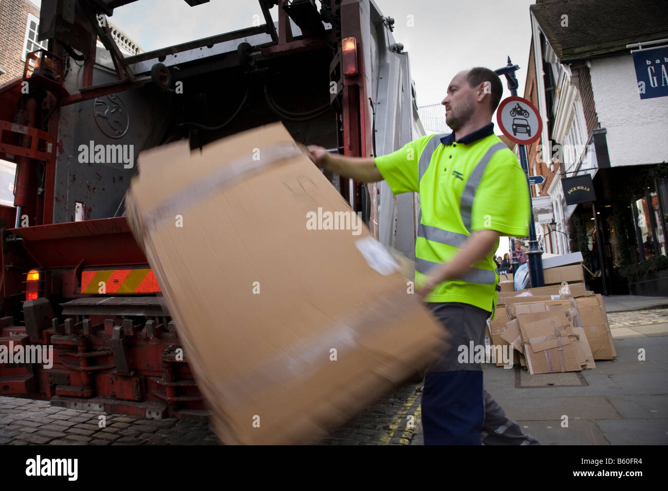 A refuse collector loads cardboard into a recycling truck, Guildofrd
