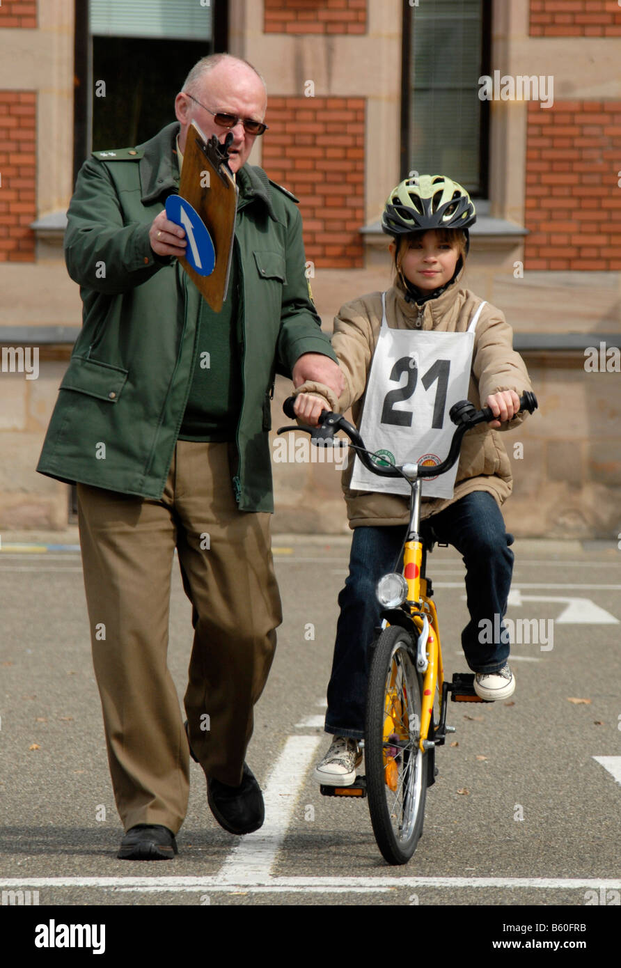 Traffic Education, 10-year-old girl on a bicycle beside a police officer Stock Photo