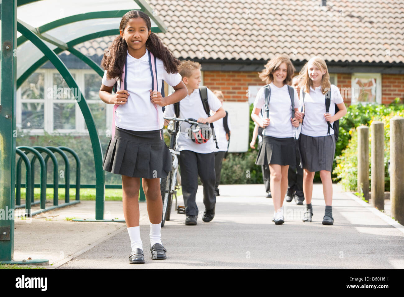 Students leaving school one with a bicycle Stock Photo