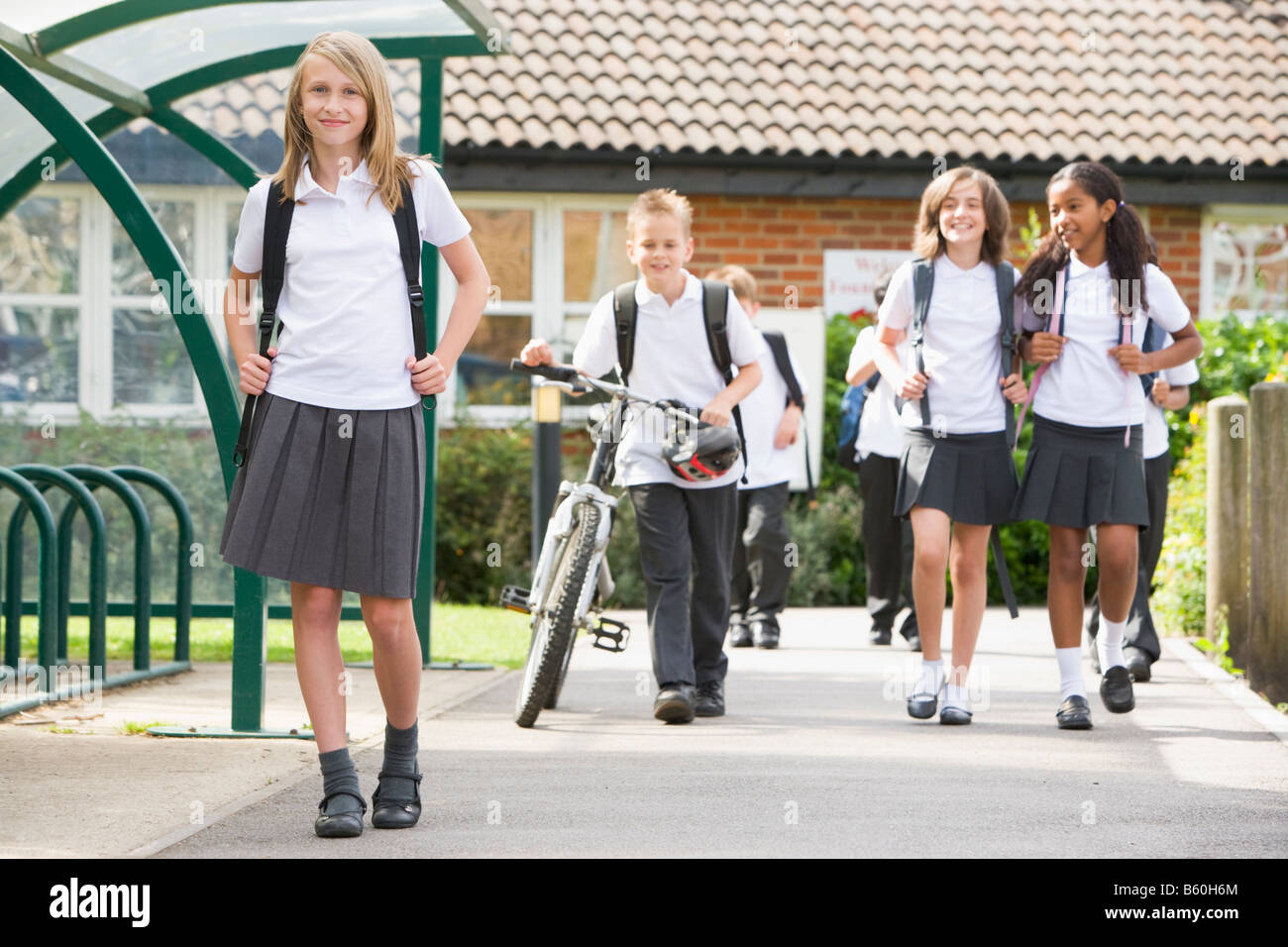 Students leaving school one with a bicycle Stock Photo