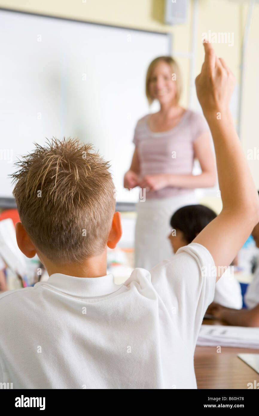 Student volunteering in class with teacher at board (selective focus) Stock Photo