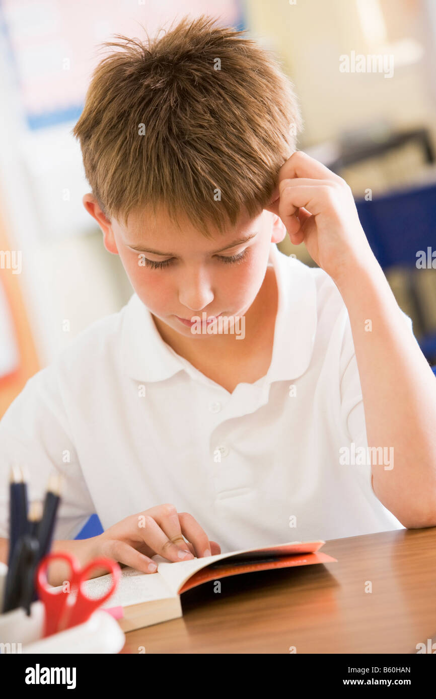 Student in class reading book Stock Photo