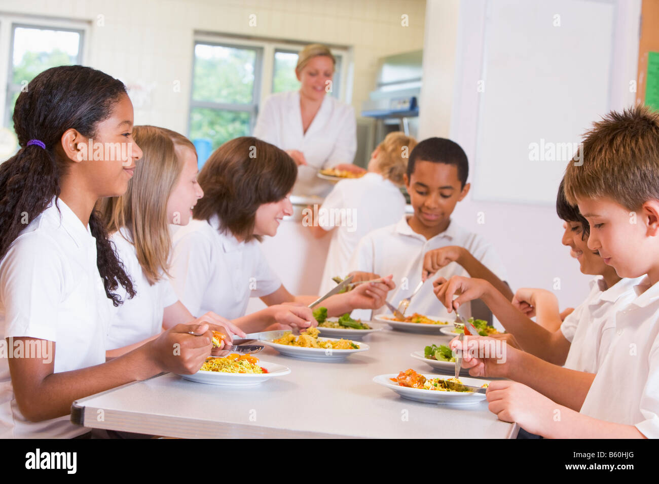 Students sitting at cafeteria table eating lunch (depth of field) Stock Photo