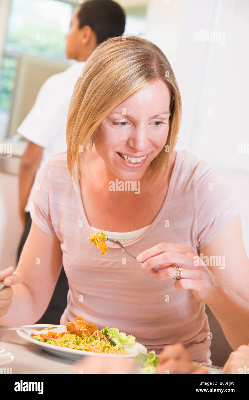 Teacher sitting at cafeteria table eating lunch Stock Photo