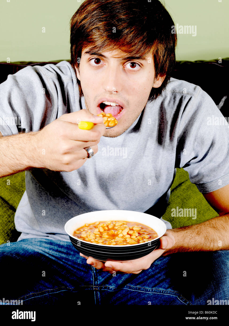 Young man eating baked beans hires stock photography and images Alamy