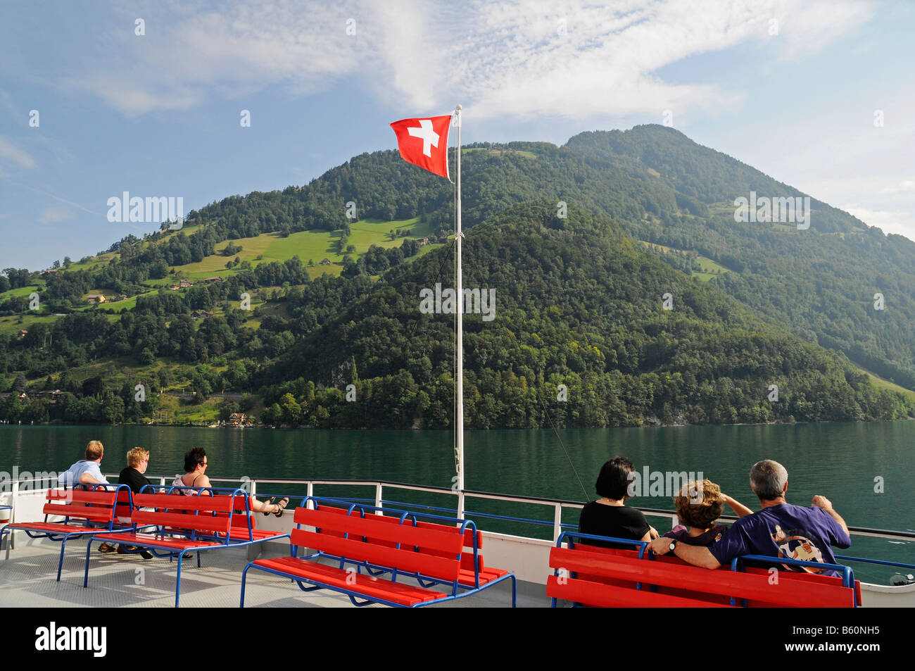 People, Swiss flag, car-ferry on its way from Beckenried to Gersau, mountains, Vierwaldstaettersee or Lake Lucerne Stock Photo