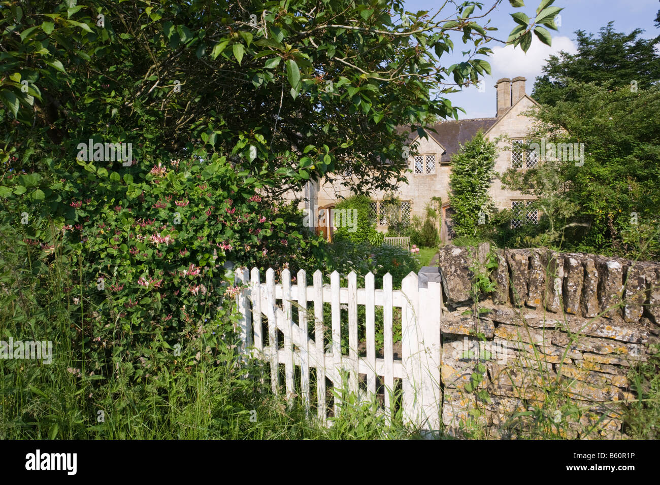 The garden gate to a rustic stone cottage in the Cotswold village of