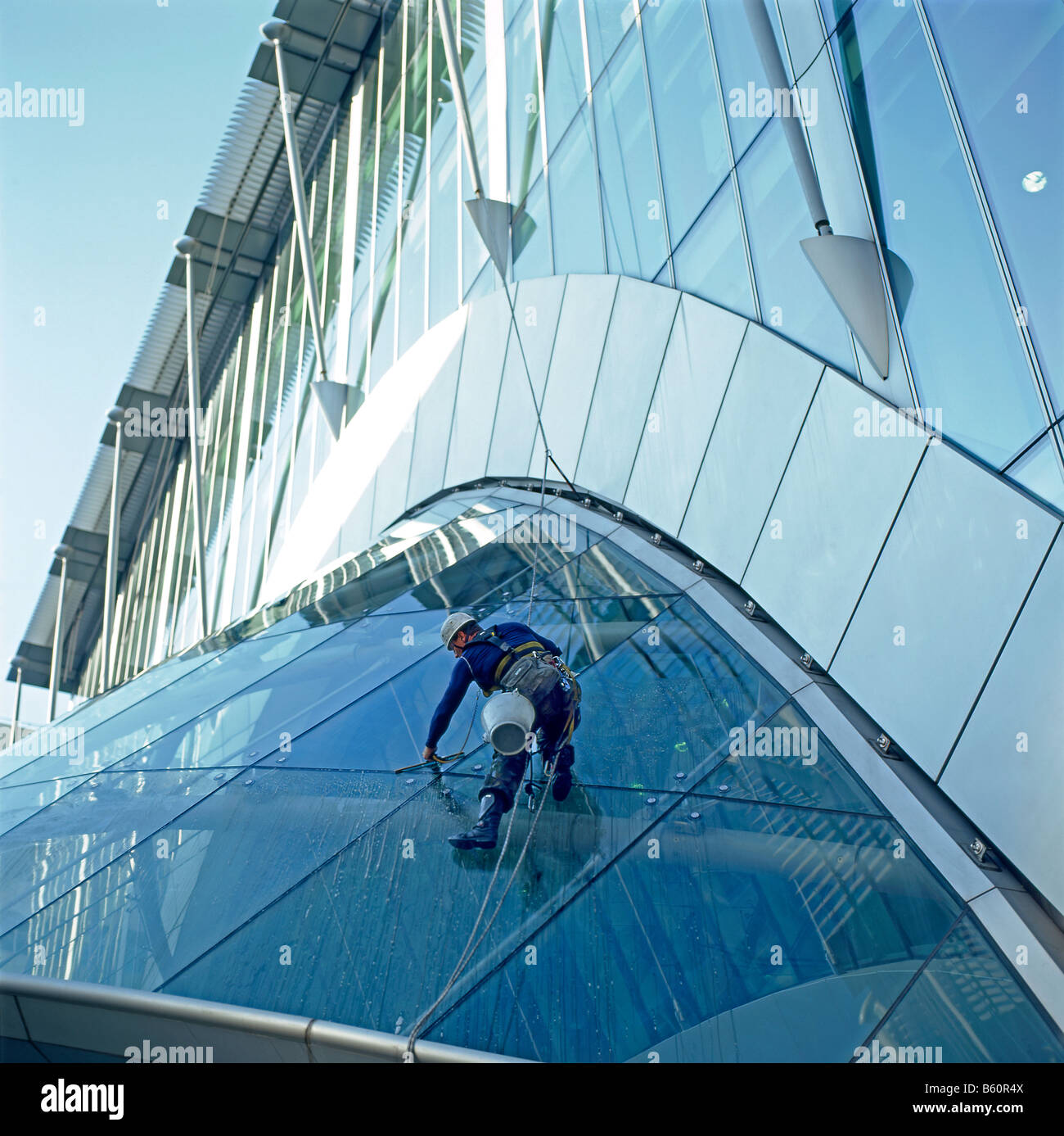 Window washer cleaning windows on the exterior foyer roof at CityPoint building in the City of London Square Mile London England UK  KATHY DEWITT Stock Photo