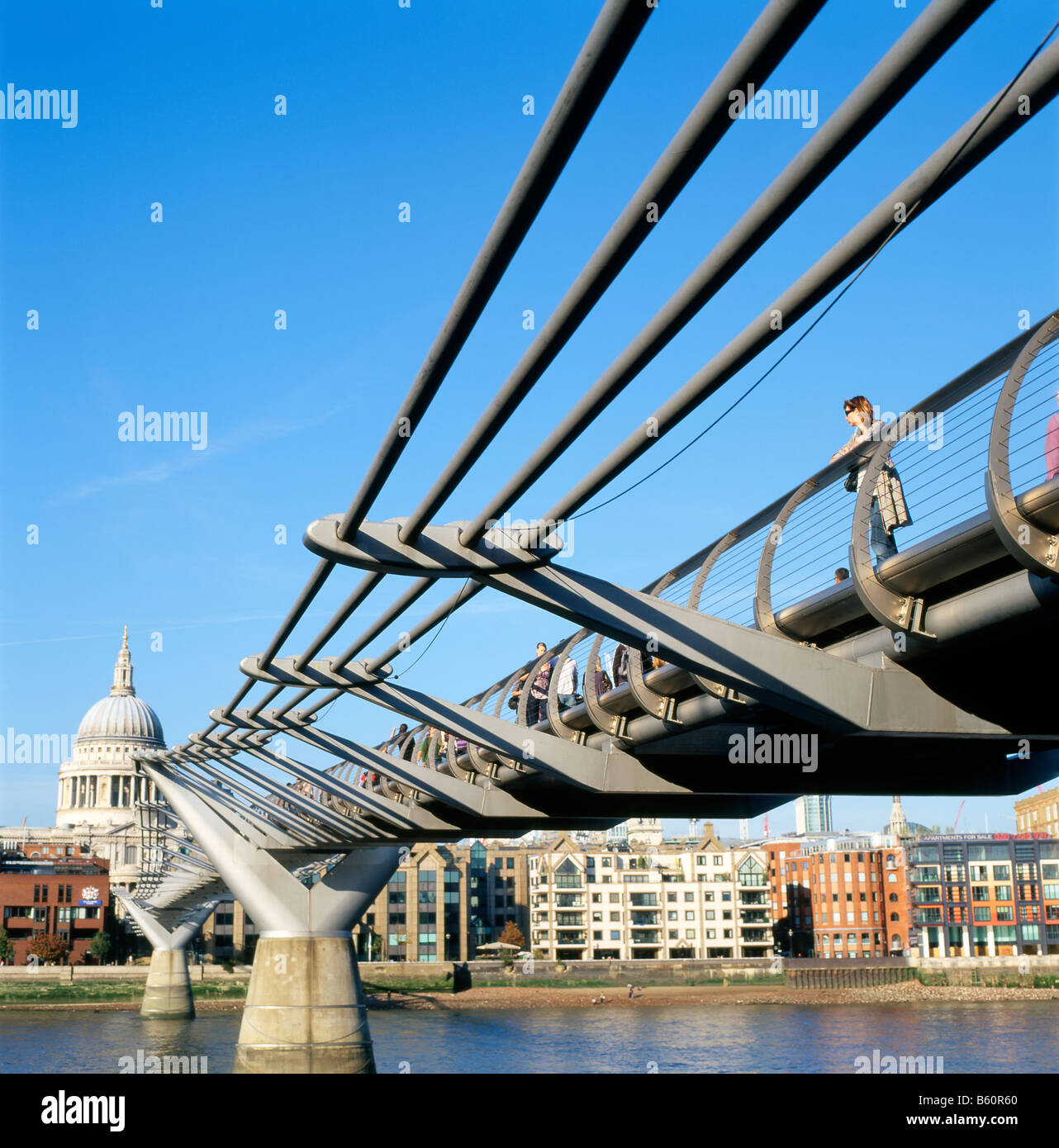 A woman tourist standing on the Millennium Bridge looking at the River Thames and Saint Pauls Cathedral London England UK   KATHY DEWITT Stock Photo