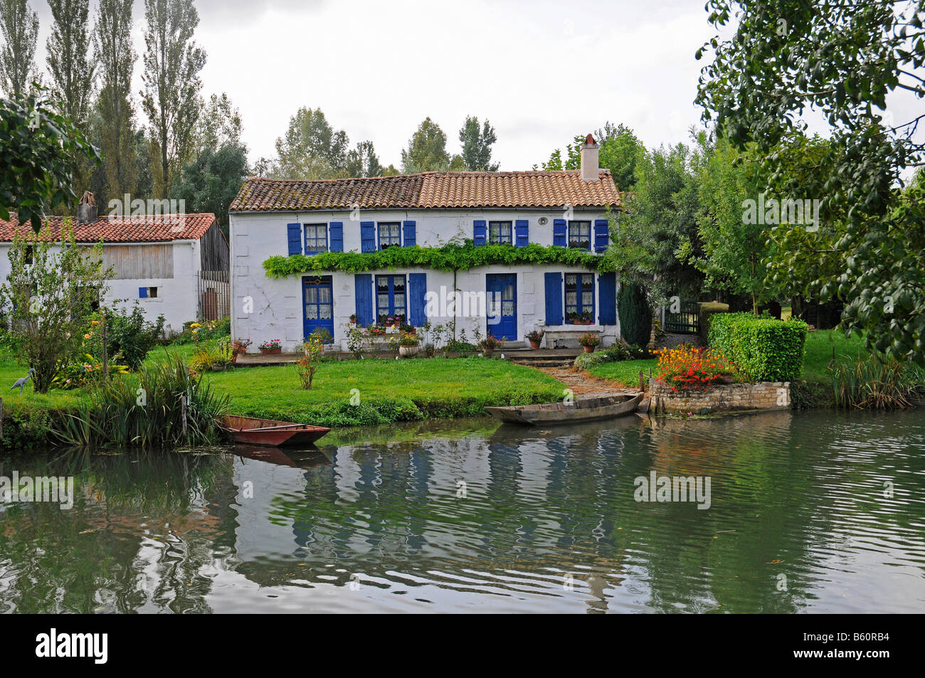 House, boat, bank, Marais Poitevin, river and marshes near Coulon, Poitou Charentes, France, Europe Stock Photo