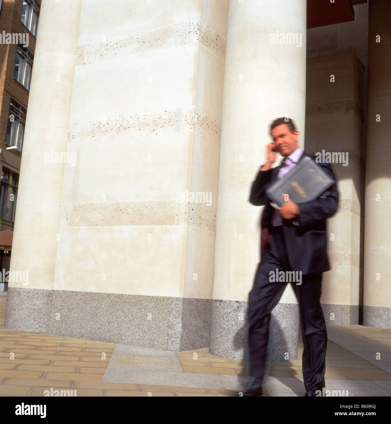 A businessman on his mobile phone leaving the London Stock Exchange building in Paternoster Square CITY OF LONDON UK October 2008   KATHY DEWITT Stock Photo