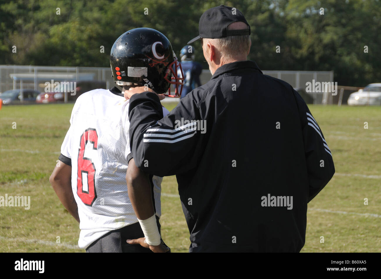 coach talks to quarterback and plans strategy at a football game in