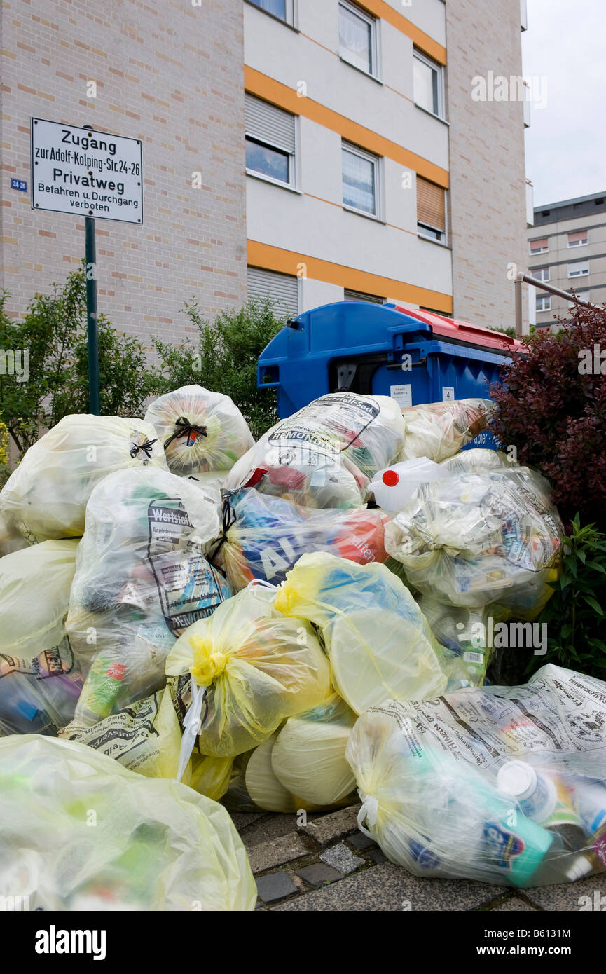 Recycling in Germany, yellow bags and waste paper in front of apartment