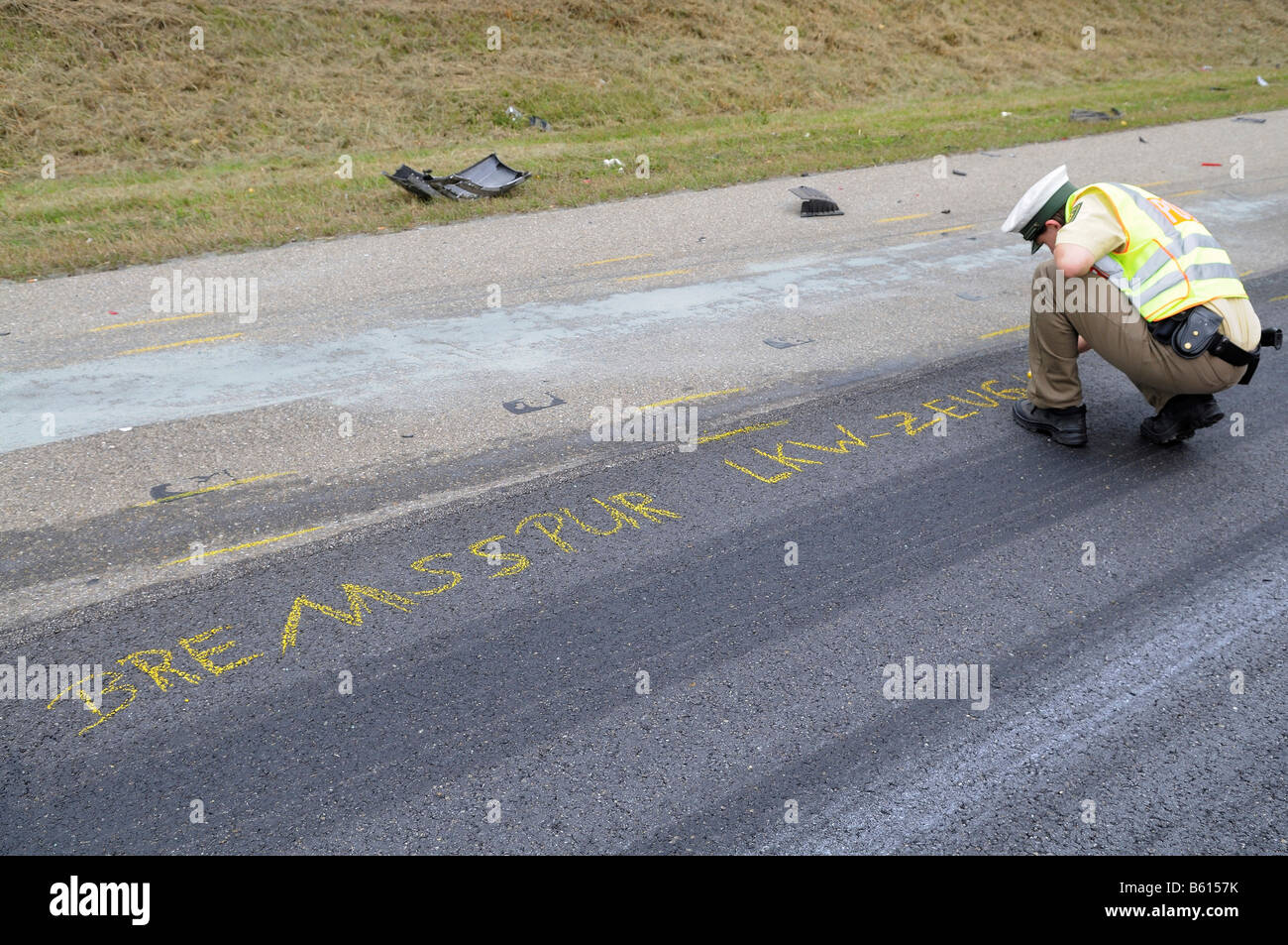 Young policewoman marking the road with crayon for accident expert