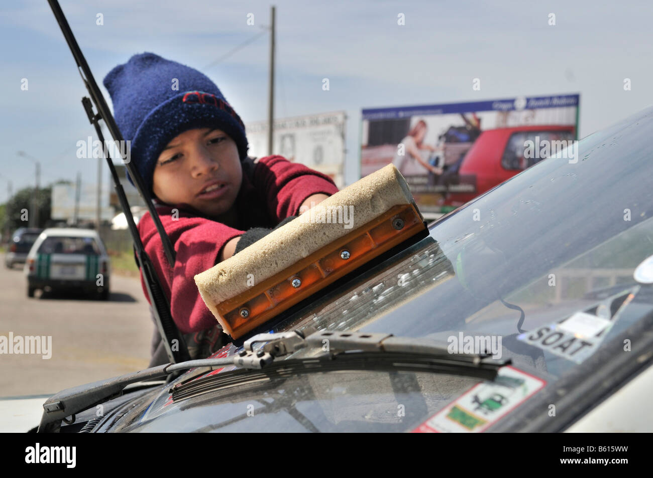 Child labour, tenyear old cleaning car windows at an intersection