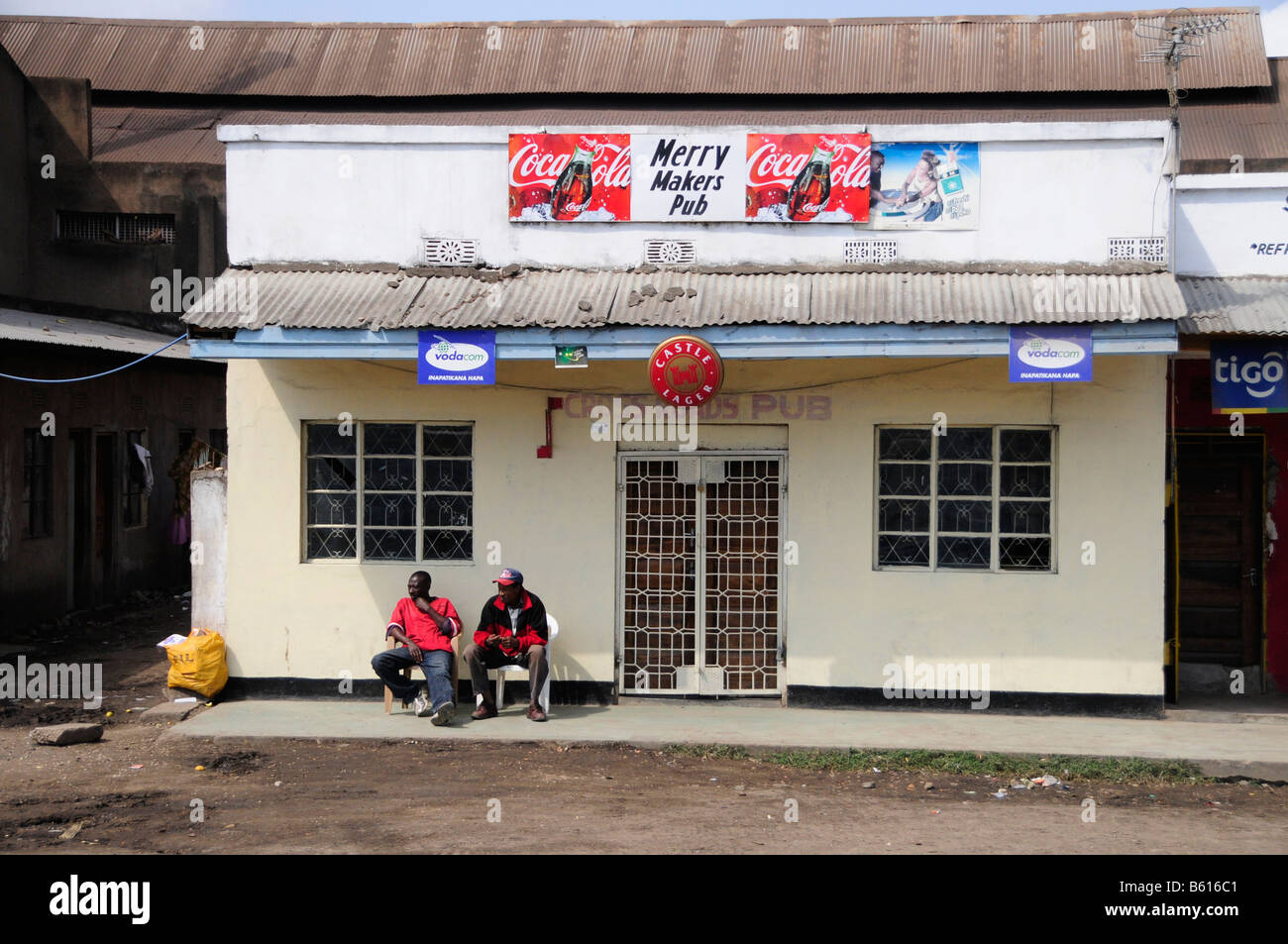 Two locals in front of a pub, Merry Makers Pub, Arusha, Tanzania, Africa Stock Photo