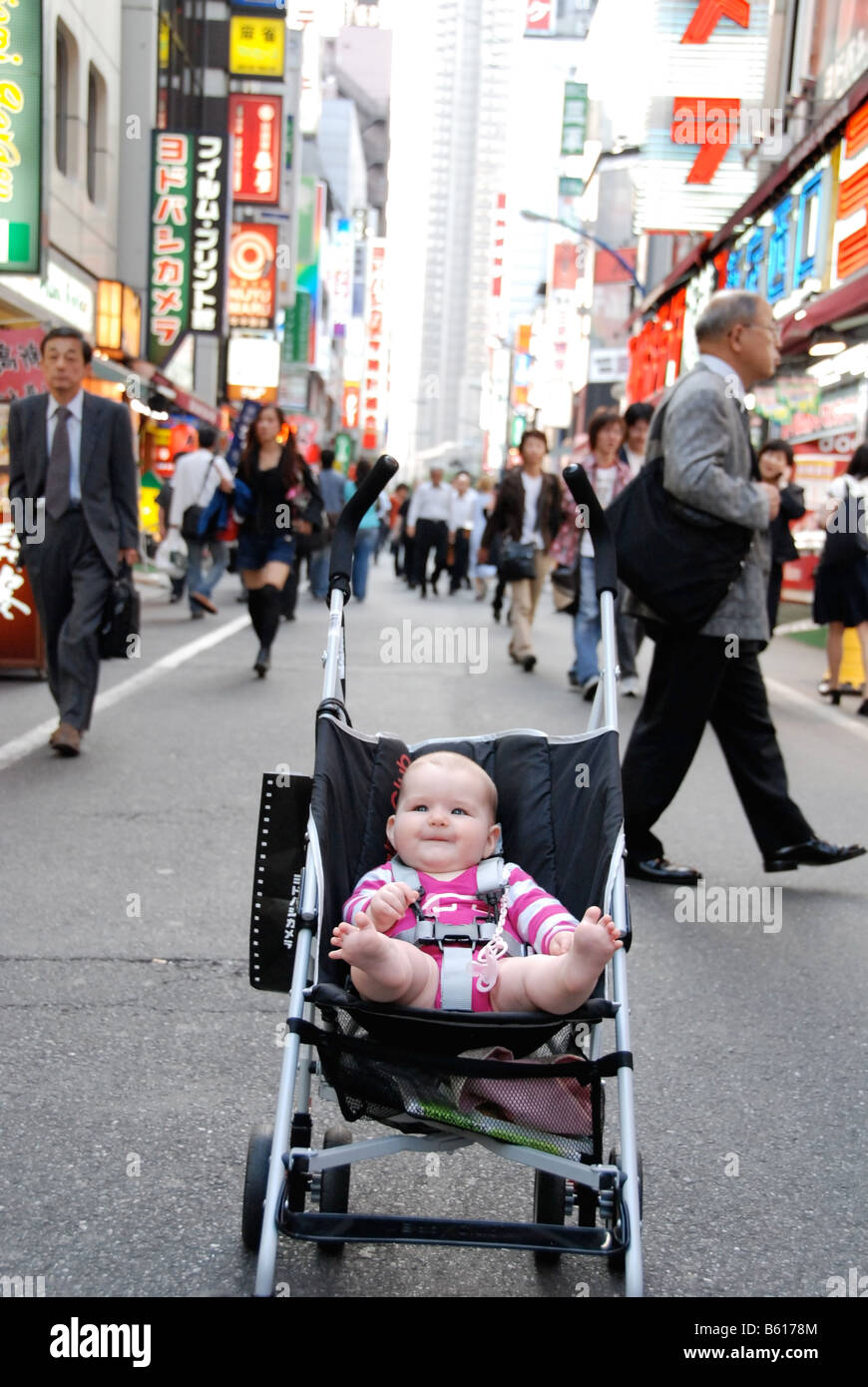 A western / caucasian baby takes in the sights of Shinjuku in Tokyo, Japan Stock Photo