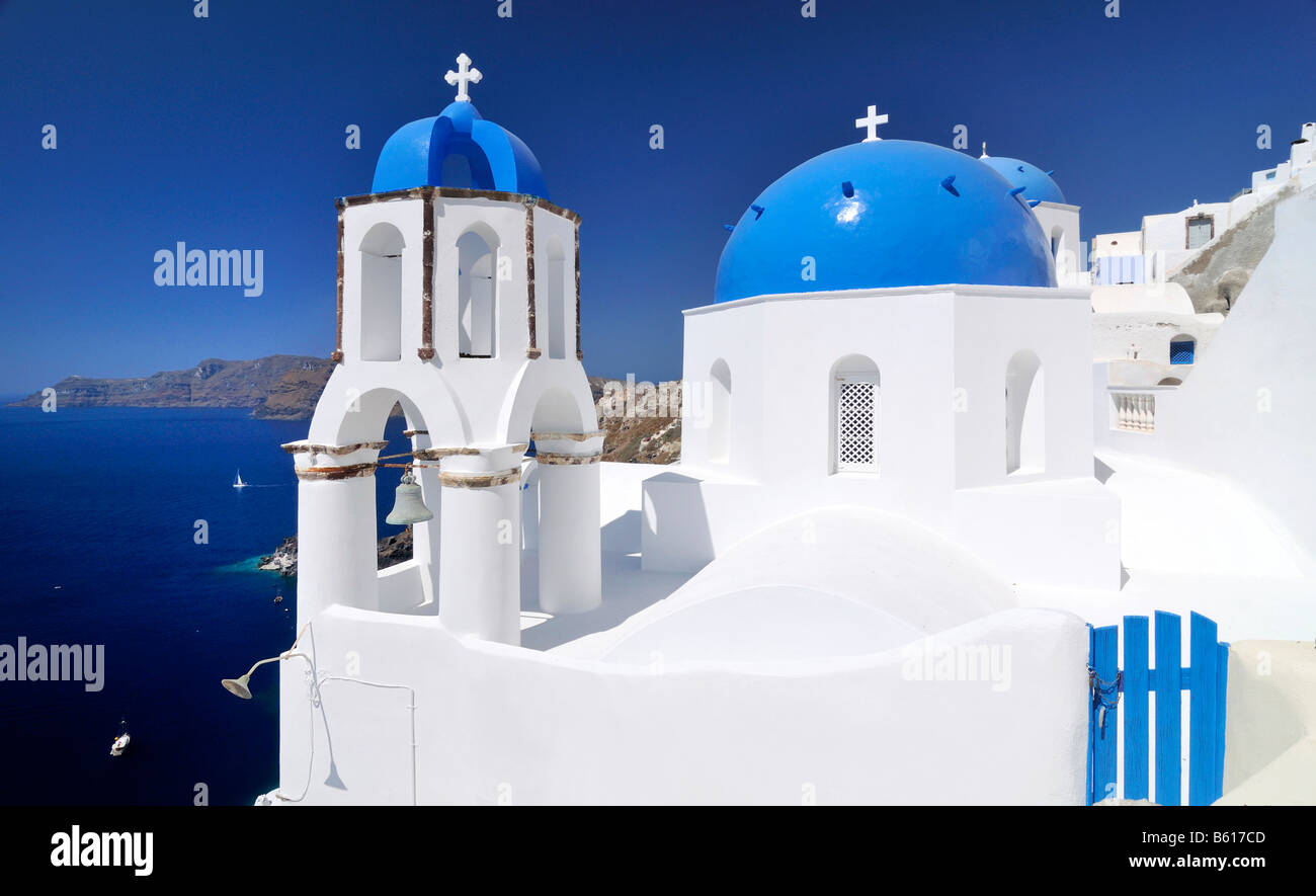Blue and white domed church and bell tower in front of the blue sea, Oia, Ia, Santorini, Cyclades, Greece, Europe Stock Photo