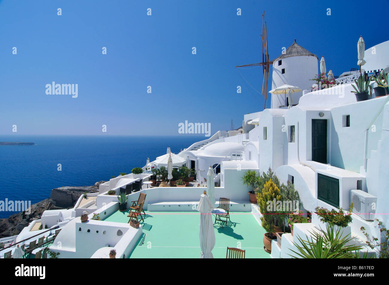 Typical Cycladic architecture and a windmill in front of the blue sea, Oia, Ia, Santorini, Cyclades, Greece, Europe Stock Photo