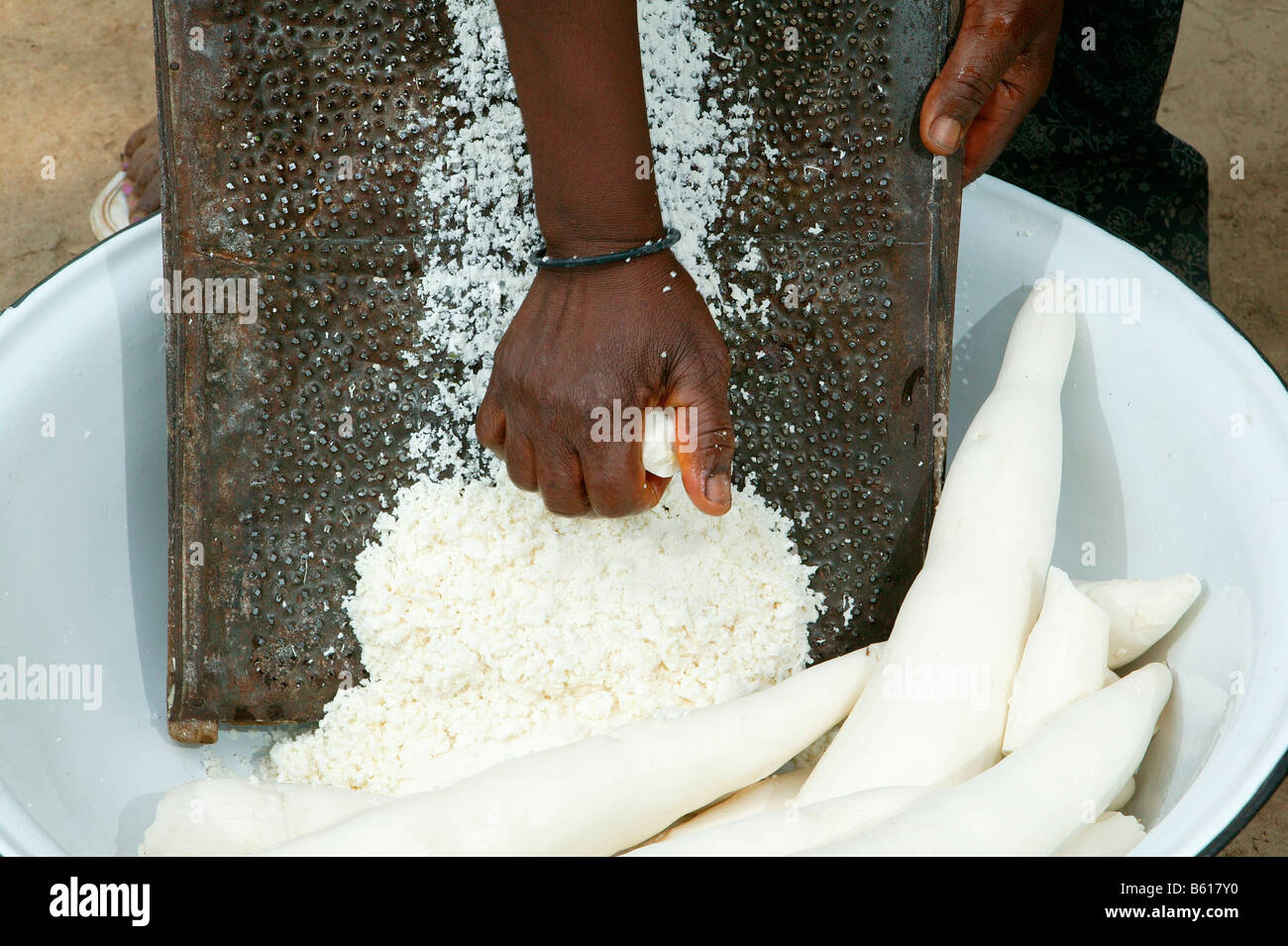 Woman grating maniok or cassava into flakes, Bamenda, Cameroon, Africa Stock Photo