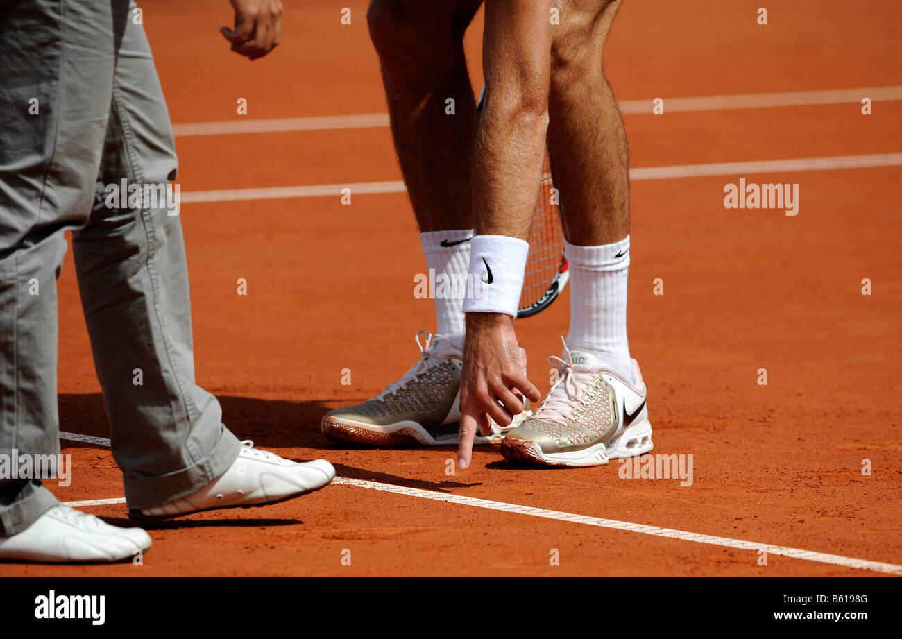Disputed referee decision at a tennis match, tennis player showing a