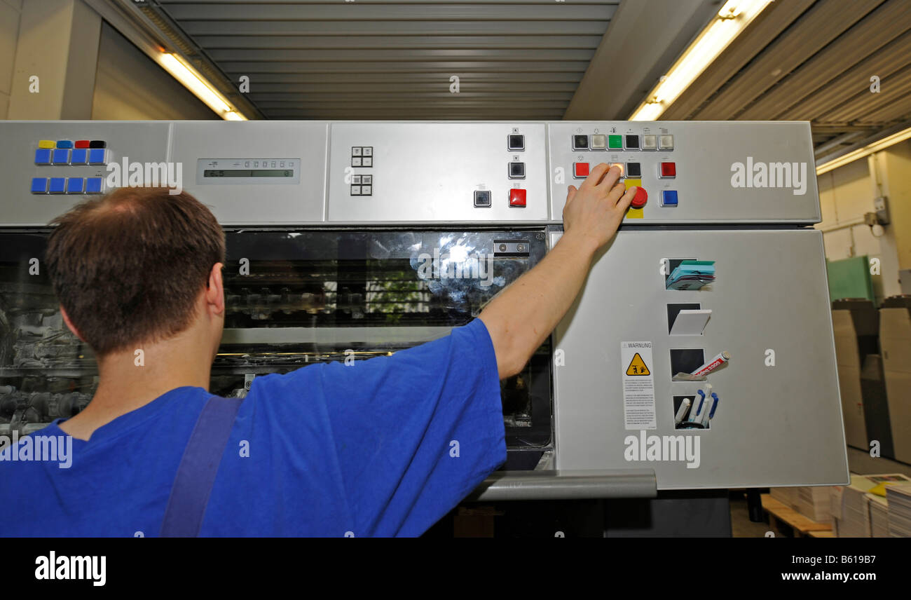 Printer operating a Heidelberg Speedmaster printing press in a printing ...