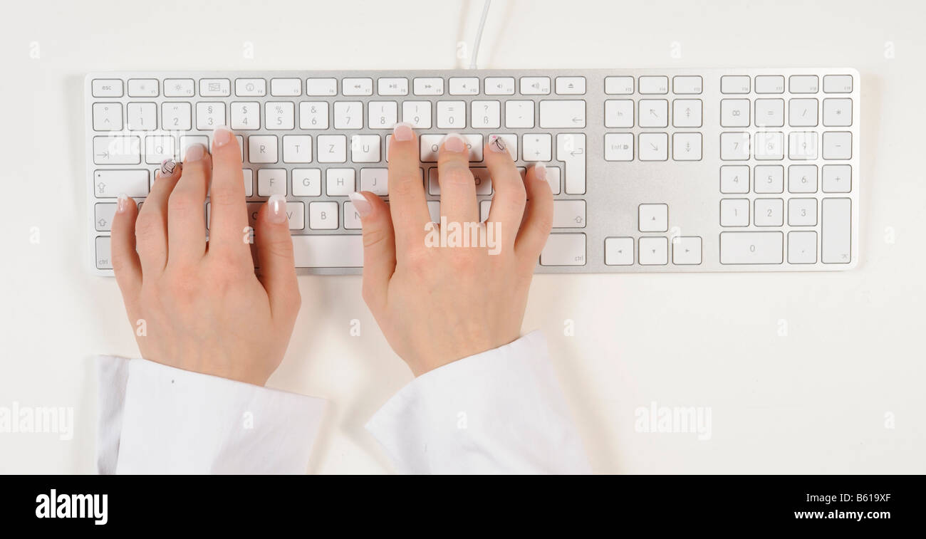 Hands typing on an Apple keyboard Stock Photo