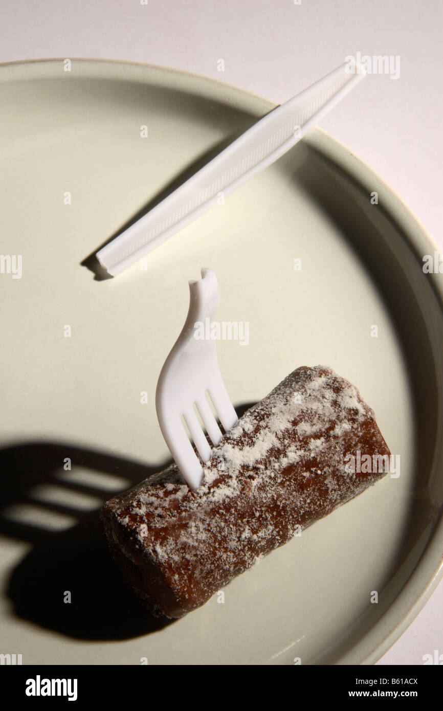 A broken plastic fork in a chocolate cake. Stock Photo