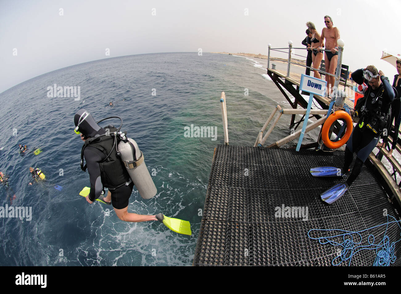 scuba diver jumping into water from jetty Stock Photo - Alamy
