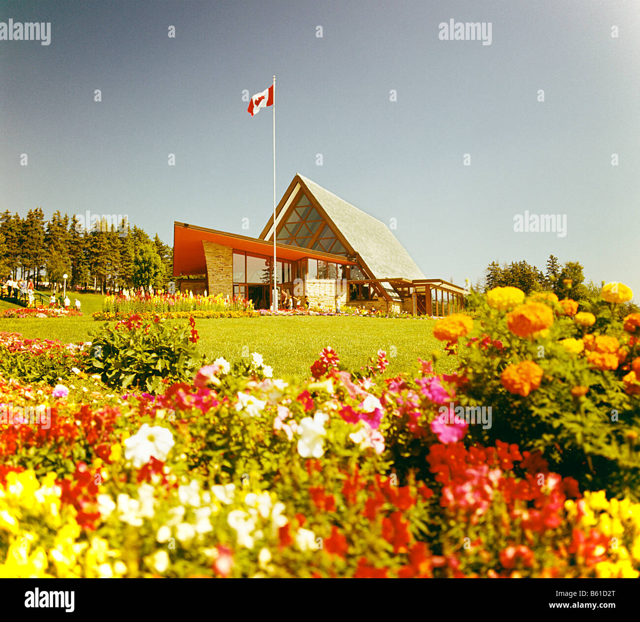 Alexander Graham Bell Museum in Cap Breton Nova Scotia,Canada with flower bed with Canadian flag and house in background Stock Photo