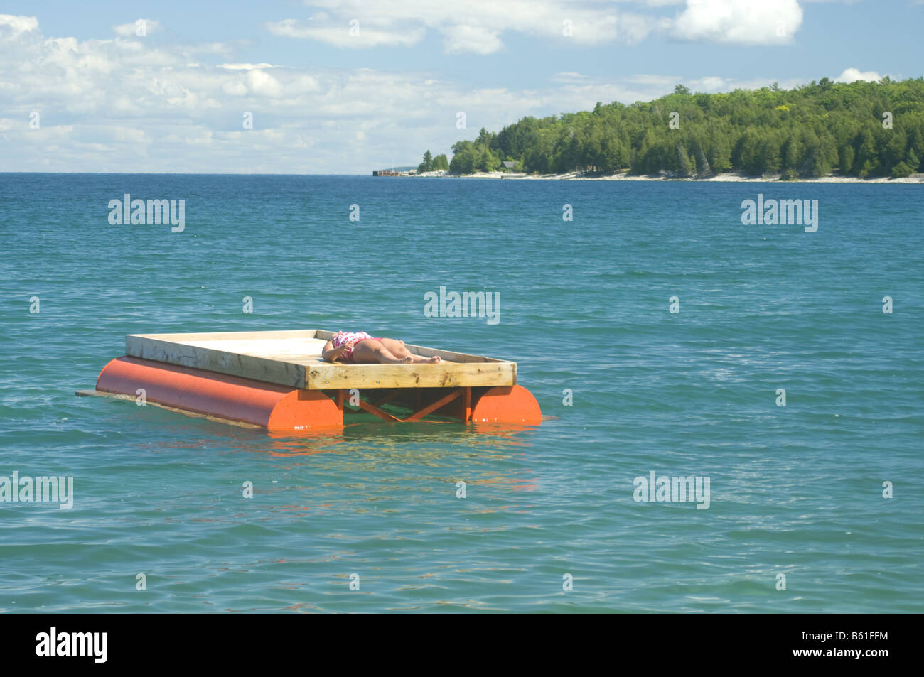 Woman Sunbathes On A Swimming Platform In Washington Harbor